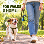 A dog walking harness and leash set being used outdoors on a park path, with a person in jeans walking alongside the dog. The leash includes a small blue and green pouch with paw print details.