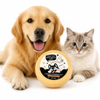 A golden retriever and a gray tabby cat are lying on a white studio background, both looking at a round yellow pet product labeled 'NOSE & PAWBALM' in front of them.