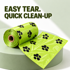 A roll of bright lime green plastic bag liners with black paw print patterns, shown partially unrolled on a light gray pedestal. Large dark olive text at the top reads 'EASY TEAR.