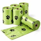 Five rolls of bright green plastic bag liners with black paw print patterns, with one roll unrolled to show the pattern on a white background.